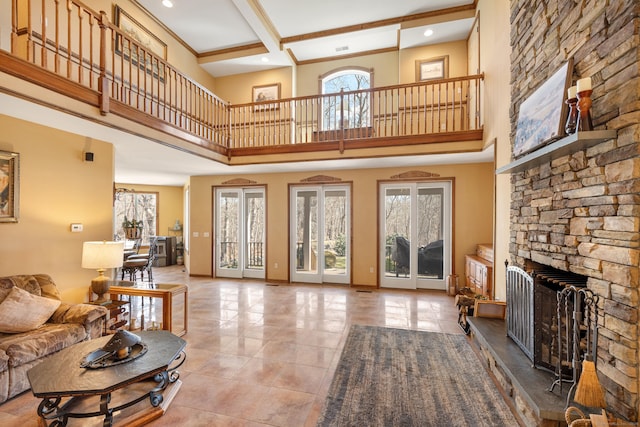 tiled living room featuring beamed ceiling, baseboards, a healthy amount of sunlight, and a fireplace