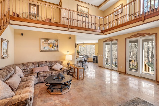 living area with baseboards and a towering ceiling