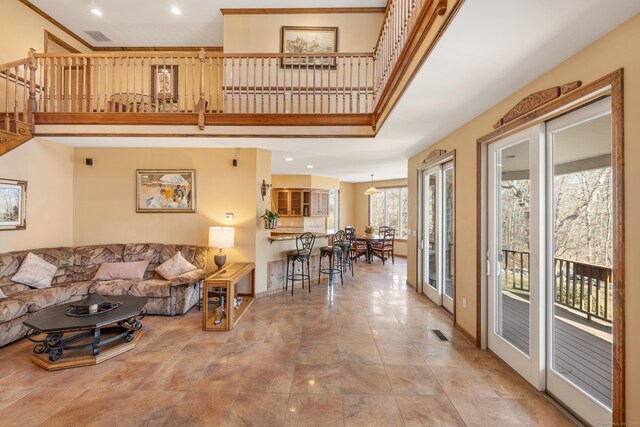 living area with visible vents, recessed lighting, a high ceiling, and baseboards