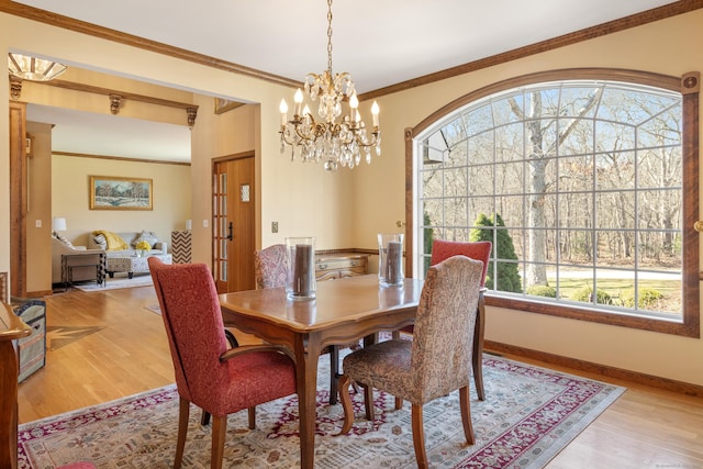 dining space with light wood-type flooring, plenty of natural light, baseboards, and crown molding