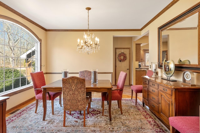 dining room with an inviting chandelier, crown molding, visible vents, and baseboards