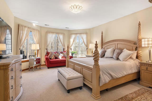 bedroom with baseboards, visible vents, and light carpet