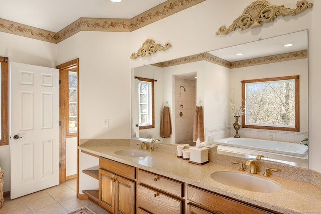 bathroom with a sink, a bathing tub, double vanity, and tile patterned flooring