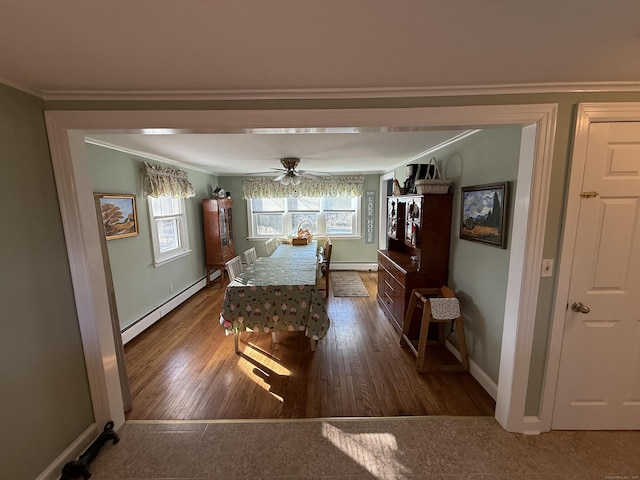 dining area with hardwood / wood-style floors, baseboards, ceiling fan, ornamental molding, and a baseboard heating unit