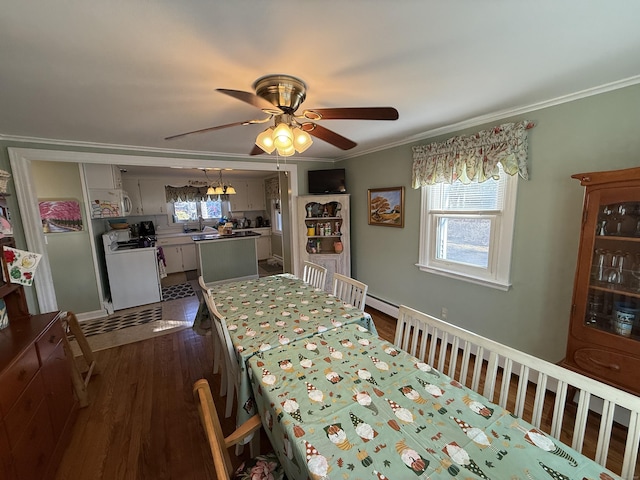 dining room with dark wood finished floors, baseboard heating, a ceiling fan, and ornamental molding