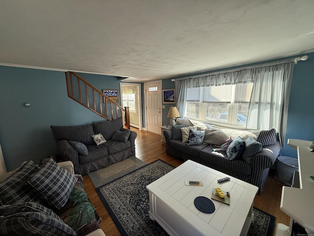 living room with wood finished floors, stairs, and ornamental molding