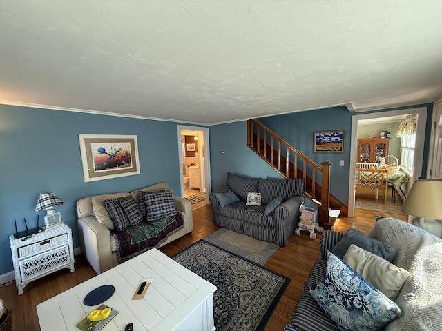 living room with stairway, a textured ceiling, wood finished floors, and ornamental molding