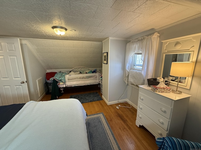 bedroom featuring crown molding, wood finished floors, and baseboards