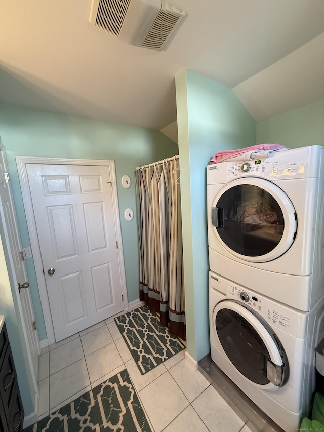 clothes washing area with light tile patterned floors, visible vents, and stacked washer and clothes dryer