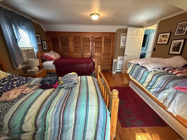 bedroom with lofted ceiling, cooling unit, and wood finished floors