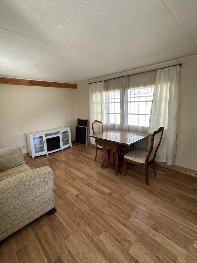 dining area with a textured ceiling and wood finished floors