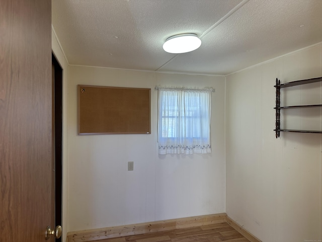 unfurnished room featuring wood finished floors and a textured ceiling