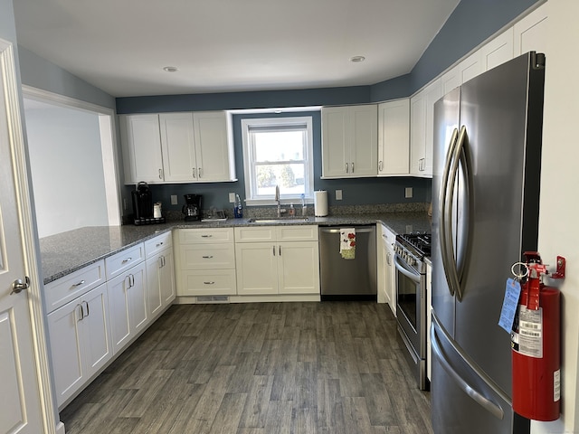 kitchen with white cabinets, dark wood-style flooring, appliances with stainless steel finishes, and a sink