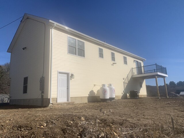 rear view of house featuring central AC unit and a deck