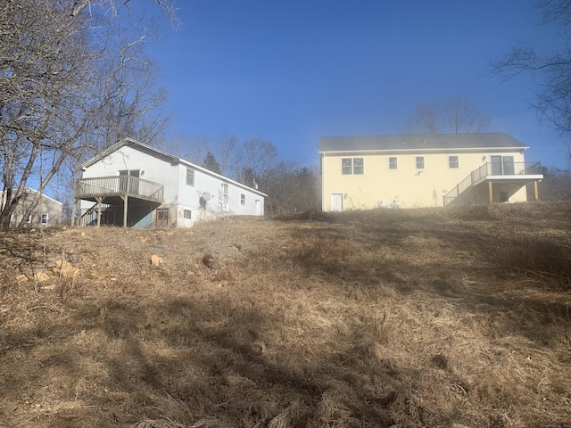 rear view of property featuring stairway and a wooden deck