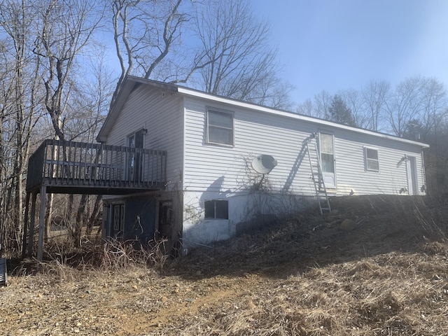view of property exterior featuring a wooden deck