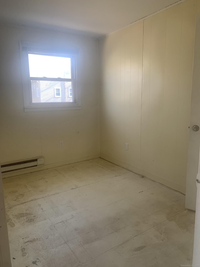 unfurnished room featuring baseboard heating