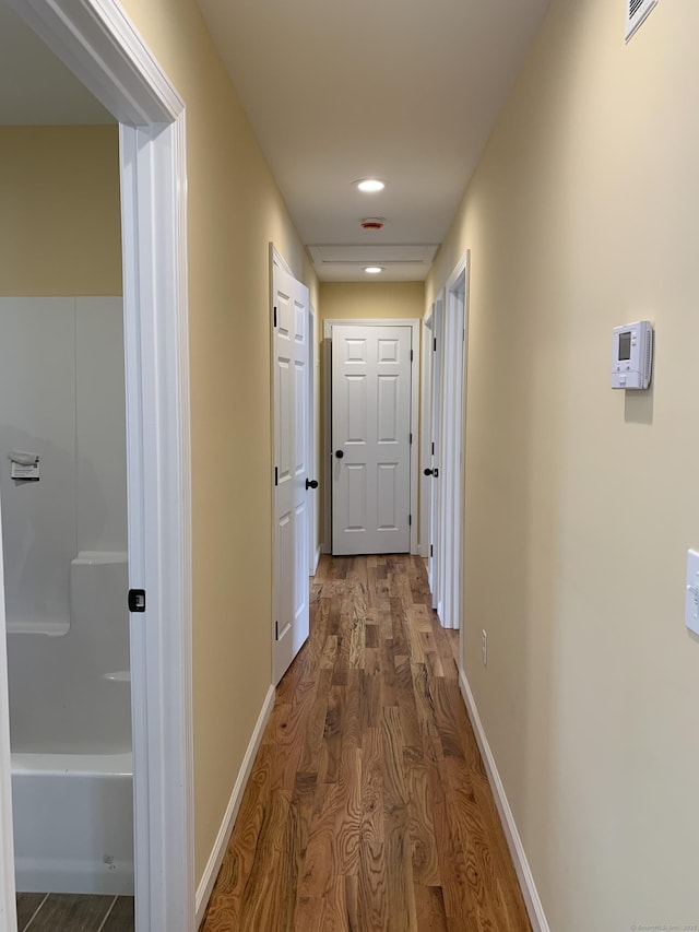 hall featuring recessed lighting, wood finished floors, and baseboards