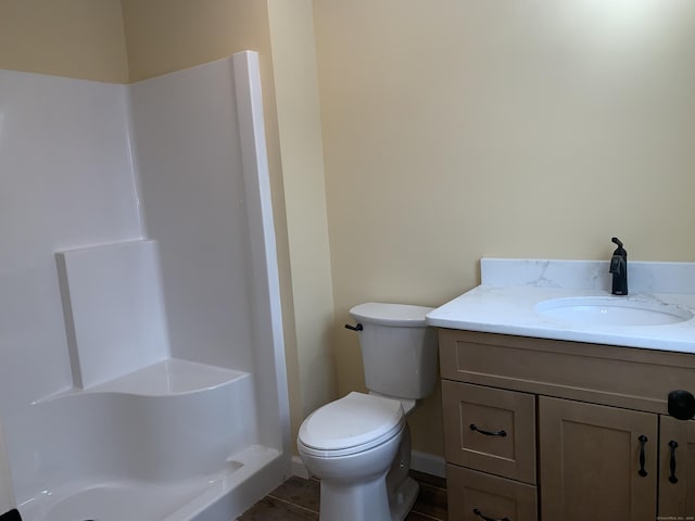 bathroom featuring vanity, toilet, tile patterned flooring, and walk in shower