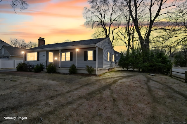 view of front of property with a chimney and fence