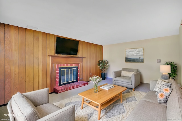 living area with a brick fireplace and wooden walls