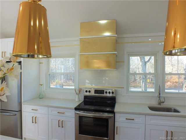 kitchen featuring a sink, backsplash, appliances with stainless steel finishes, and white cabinets