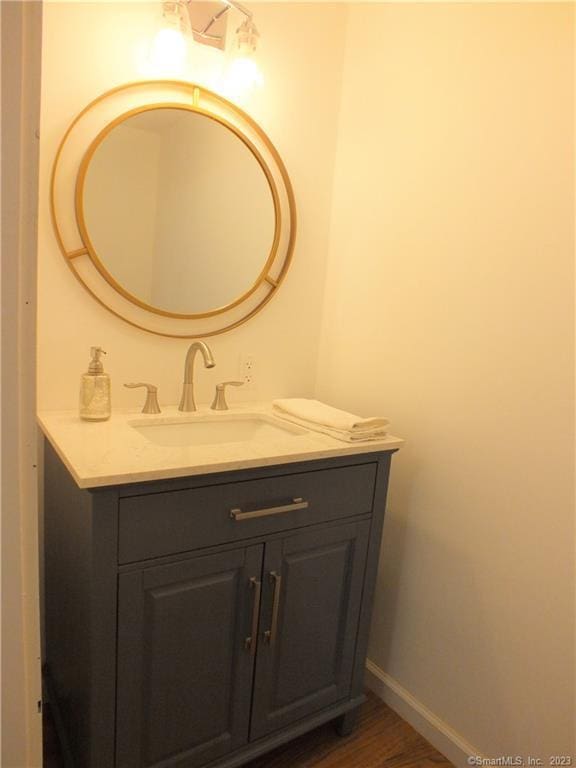 bathroom with vanity, baseboards, and wood finished floors