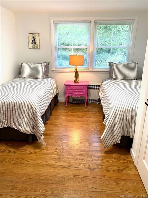 bedroom with light wood-type flooring and radiator heating unit