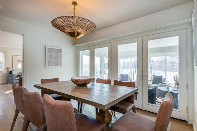 dining room featuring a wealth of natural light, french doors, and light wood-style flooring