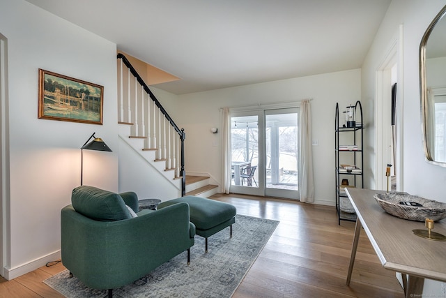 living area featuring wood finished floors, baseboards, and stairs