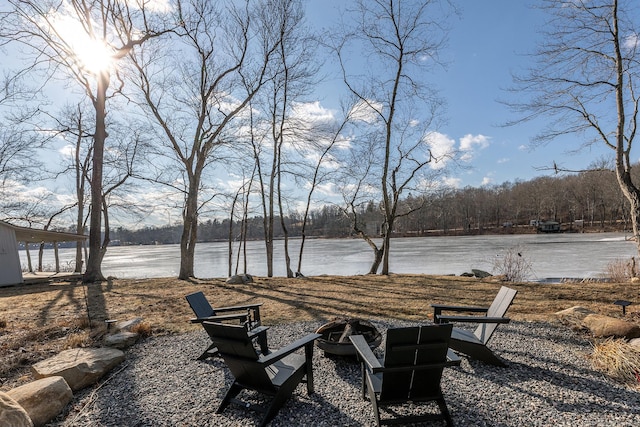 view of yard with an outdoor fire pit and a water view