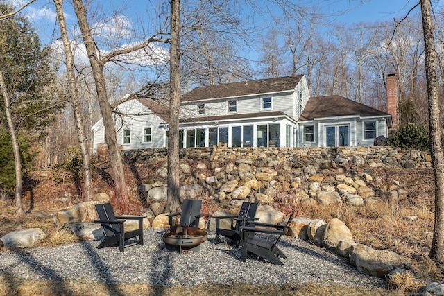 back of house featuring a chimney, an outdoor fire pit, and french doors