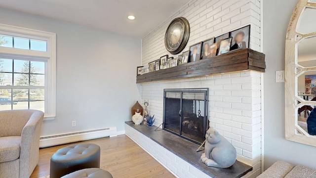 living room with recessed lighting, a brick fireplace, wood finished floors, and a baseboard radiator