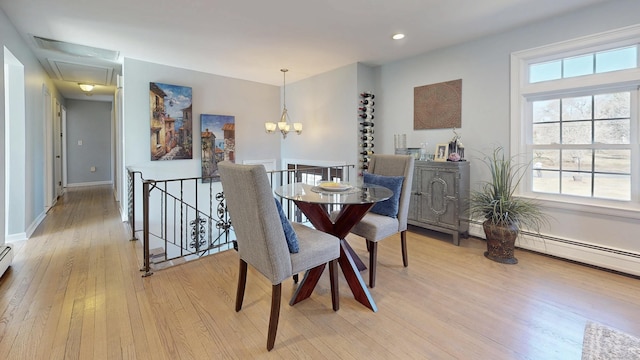 dining area featuring light wood-type flooring, baseboards, and an inviting chandelier