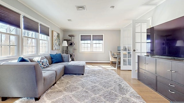 living area with light wood finished floors, visible vents, a baseboard heating unit, and crown molding