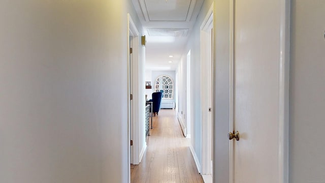 corridor featuring baseboards and light wood finished floors