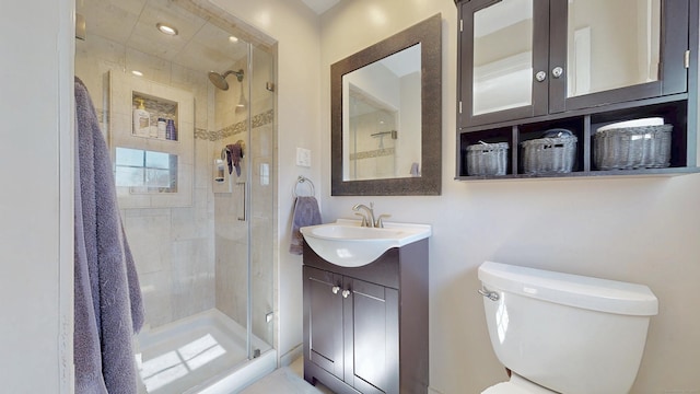 full bath featuring toilet, a stall shower, and vanity