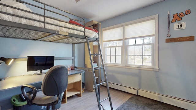 bedroom featuring wood finished floors and a baseboard radiator