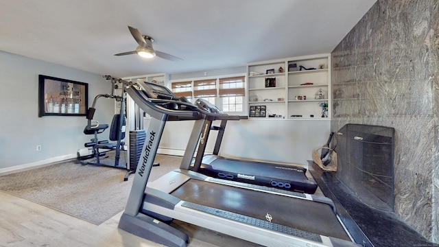 workout area featuring wood finished floors, baseboards, and ceiling fan