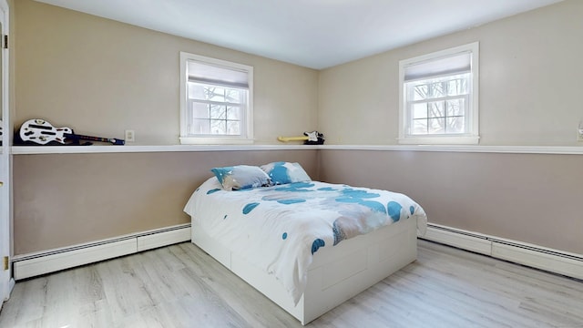 bedroom featuring a baseboard heating unit and wood finished floors