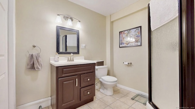 bathroom featuring tile patterned flooring, toilet, vanity, and baseboards