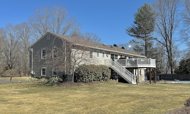 rear view of property with a deck, stairway, a lawn, and fence