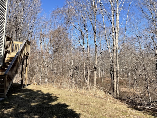 view of yard with a view of trees and stairs