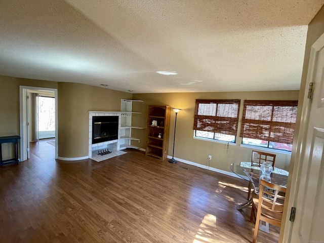 unfurnished living room with dark wood-style floors, a fireplace, and a textured ceiling