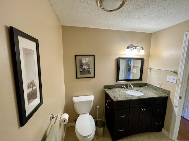 bathroom with tile patterned floors, a textured ceiling, toilet, and vanity