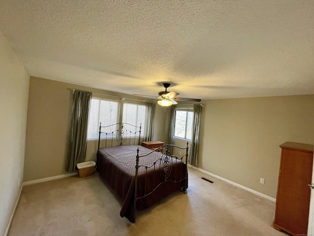 bedroom with light colored carpet, baseboards, and ceiling fan