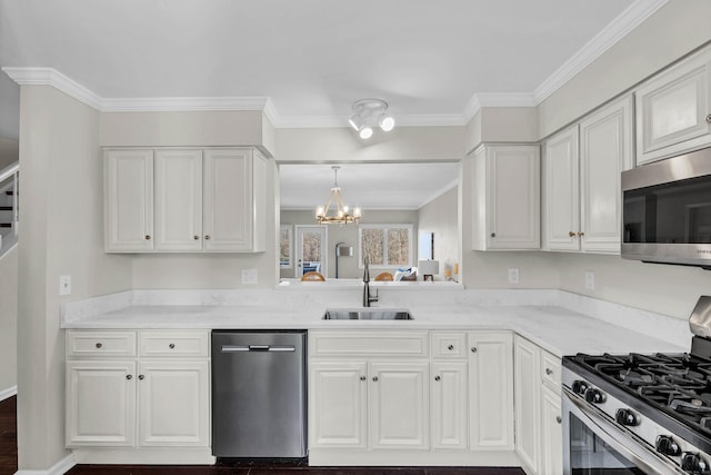 kitchen featuring a sink, a chandelier, stainless steel appliances, white cabinets, and ornamental molding