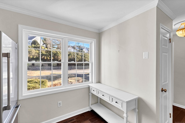 interior space featuring dark wood finished floors, baseboards, and ornamental molding