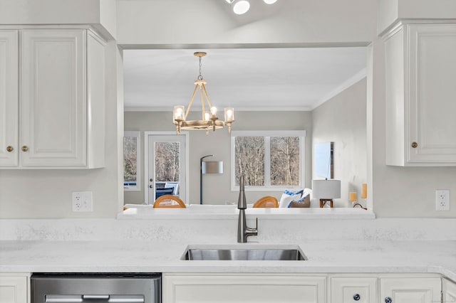 kitchen with a sink, white cabinets, ornamental molding, and light countertops