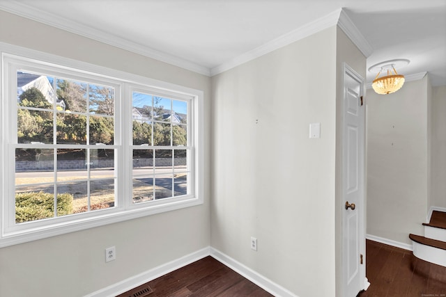 empty room with dark wood finished floors, baseboards, and ornamental molding